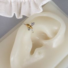 a pair of earrings sitting on top of a white object