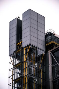 an industrial building with scaffolding on the front and side walls that are yellow