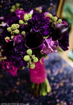 a bouquet of purple flowers sitting on top of a table