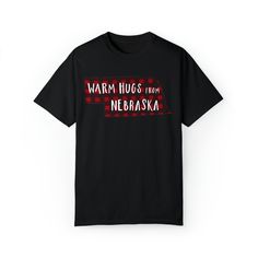 Black unisex short sleeve T-shirt With red and black Warm Hugs from Nebraska design of the chest. Black School Spirit T-shirt With Slogan, Black T-shirt With Funny Text For School Spirit, Black School Spirit T-shirt With Funny Text, Funny Cotton College T-shirt, Funny Cotton T-shirt For College, Funny College Short Sleeve T-shirt, Funny College T-shirt With Short Sleeves, Off To College, Warm Hug