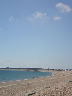 people are flying kites at the beach on a sunny day with clear blue skies