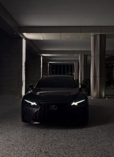 a car is parked in the middle of an empty parking garage with its lights on