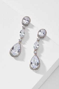 The mix of oval and pear-shaped cubic zirconia stones add a modern twist to these classically chic and elegant drop earrings. A favorite for weddings and special occasions, these stunning beauties sparkle from every angle in an understated way. Elegant Cubic Zirconia Drop Bridal Earrings, Elegant Pear-shaped Teardrop Earrings In Cubic Zirconia, Elegant Pear-shaped Teardrop Earrings With Sparkling Stones, Elegant Oval Crystal Earrings, Elegant Oval Chandelier Earrings For Weddings, Elegant Diamond White Oval Bridal Earrings, Elegant Oval Diamond White Bridal Earrings, Elegant Cubic Zirconia Teardrop Pendant Earrings, Elegant Cubic Zirconia Teardrop Earrings