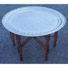 a silver tray sitting on top of a wooden table in the middle of a parking lot