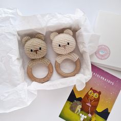 two crocheted teddy bears sitting in a box next to a card and book