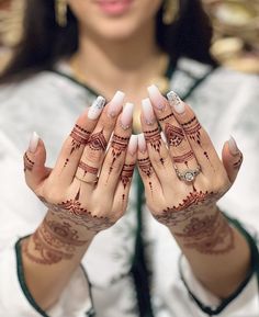 a woman is holding her hands with hendi tattoos