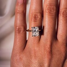 a woman's hand with a ring on it and a diamond in the middle