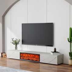 an entertainment center with a large television mounted on the wall and a fireplace in front of it