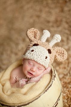 a baby is wearing a crocheted hat with a giraffe on it