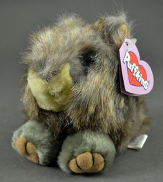 a stuffed animal with a tag on it's ear and fur around its neck