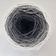 white and gray yarn is in a ball