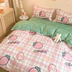 a pink and green bed set with strawberrys on the comforter, pillows and pillow cases