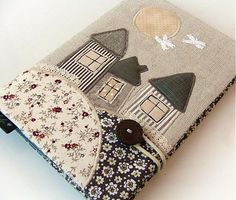 a small notebook covered in fabric with houses on it