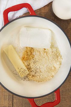 ingredients in a pan on a wooden table including butter, flour and other food items