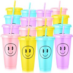 six different colored cups with smiley faces and straws in them, all lined up