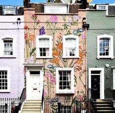 a row of houses with painted flowers on the side and stairs leading up to them