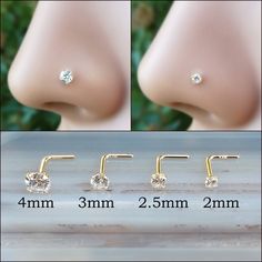 three pairs of nose piercings with clear crystal stones on each side and two different sizes