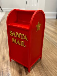 a red mailbox sitting on top of a hard wood floor