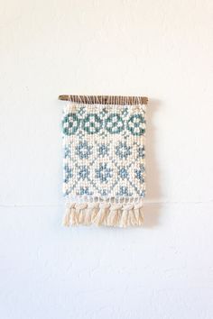 a white and blue wall hanging on the side of a wall