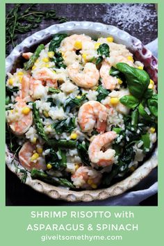 a bowl filled with shrimp and vegetables on top of a table next to some bread