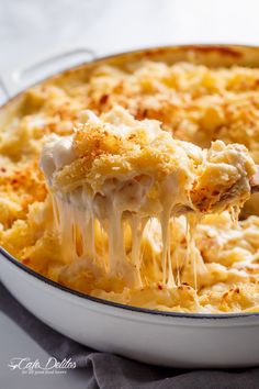 a casserole dish with macaroni and cheese being lifted from it