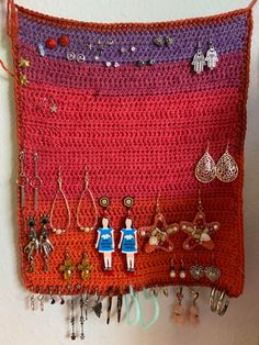 a crocheted wall hanging with earrings on it