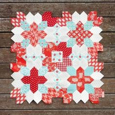 a red, white and blue patchwork quilt on a wooden background with text overlay