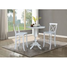 a white table and two chairs sitting on top of a rug