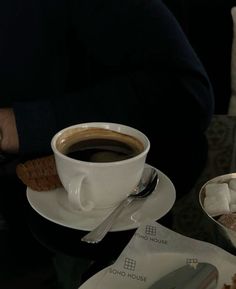 a cup of coffee sitting on top of a saucer next to a plate of food