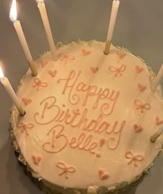 a birthday cake with white frosting and lit candles