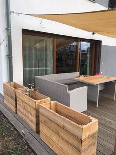 some wooden planters sitting on top of a deck next to a table and chairs