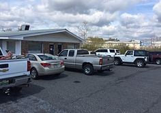 several pickup trucks parked in a parking lot