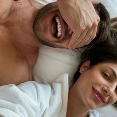 a man laying in bed next to a woman