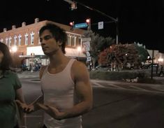 a man and woman standing in the street at night