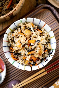 a bowl filled with rice and vegetables on top of a table