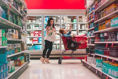 a woman pushing a shopping cart through a grocery store