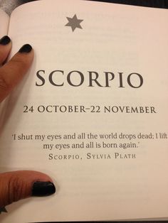 a woman's hand holding an open book with the words scorpio on it