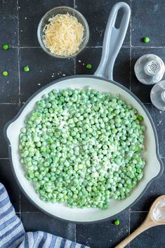 peas and parmesan cheese in a skillet ready to be cooked on the stove