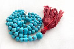 "NEW BEGINNINGS MALA - Matte Howlite Mala Necklace - 108 Bead Mala - Hand Knotted With Silk Tassel - 8mm Length 35\" - 6mm Length 30\" Keep it simple with this Mala necklace from True Nature Jewelry. This hand knotted Mala features vibrant Turquoise colored Howlite gemstone beads and electric Red knots between each bead. The focus of this Mala is on teaching patience and calming turbulent emotions. This is a stone associated with new beginnings and discoveries. A soft spun Silk tassel dangles fr Bohemian Single Strand Beaded Necklace For Meditation, Bohemian Single Strand Beads For Gifts, Bohemian Single Strand Beads As Gift, Spiritual Single Strand Beads As Gift, Turquoise Hand-strung Beads For Gifts, Handmade Turquoise Beaded Necklaces For Meditation, Teaching Patience, Yin Yang Charm, Knotted Mala