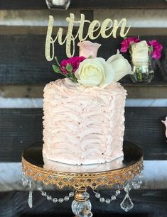 a pink cake sitting on top of a table