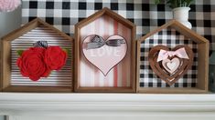 three small wooden houses with hearts and flowers in front of a fireplace mantel decorated for valentine's day