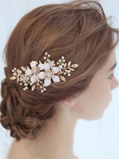 a woman wearing a bridal hair comb with flowers on it's side and pearls in the back