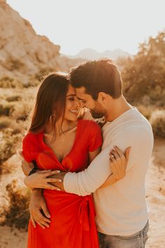 a man and woman embracing each other in the desert