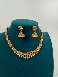 This exquisite piece of craftsmanship comes from our Traditional collection. Finish: 24 grams gold finish Necklace Fastening: Adjustable Dori Earring Fastening: Push Back Contains: 1 necklace, 1 pair of earrings Antique Gold Necklace, Gold Necklace Indian, Temple Jewelry, Necklace Indian, South Indian Jewelry, Jewellery Sets, Indian Wedding Jewelry, Wedding Jewellery, Temple Jewellery