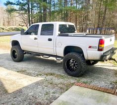 a white pickup truck parked in front of some trees