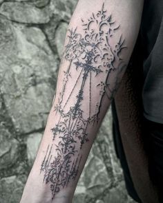 a person with a tattoo on their arm that has flowers and vines all over it