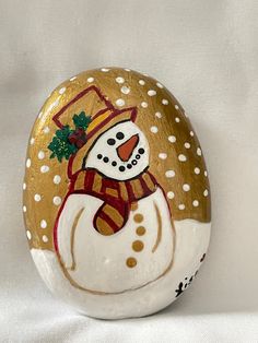 a painted rock with a snowman on it