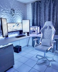 a white chair sitting in front of two computer monitors