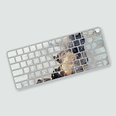 a computer keyboard with broken glass on the bottom and bottom keys, all covered in gold foil