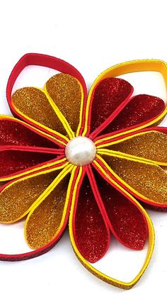 a red and yellow flower with a pearl in it's center on a white background